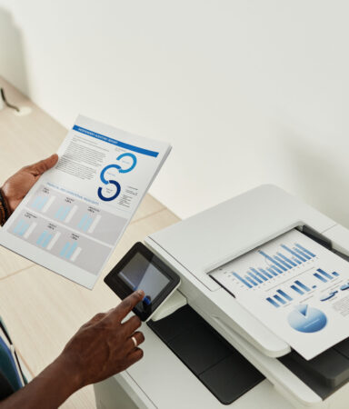 Serious entrepreneur printing out annual reports for meeting with coworkers